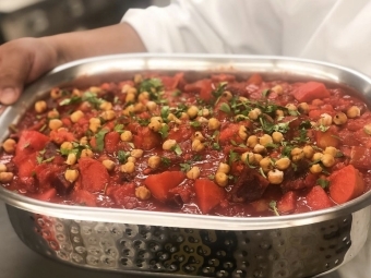 Chef Holds Up Plant Based Dish at Commons