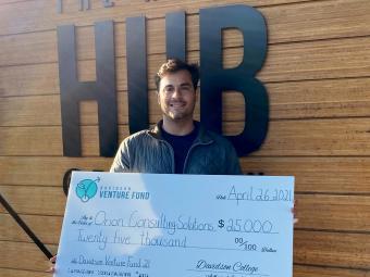 Owen Bezick '21 Claims Prize Check in Front of Hurt Hub