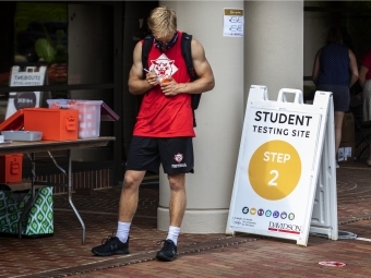 Student at COVID Testing Site on Campus Labelling Collection Tube