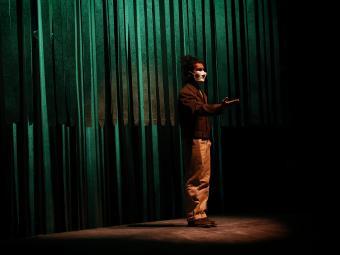 Student Performing in Theatre Piece with Mask