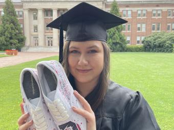 Photo of Julia Miller in front of the Chambers Building with shoes she decorated