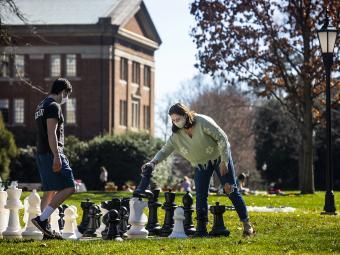 students play giant chess on campus lawn