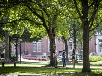 Students Conducting Binocular Experiment on Campus Surrounded by Trees