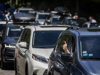Cars Line Up for Move In, person in car does thumbs up out of passenger window