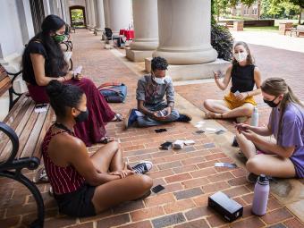 Students Playing Card Game in Masks in a Circle