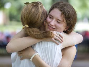 Student Says Goodbye to Family and Hugs Family Member at Farewell Picnic