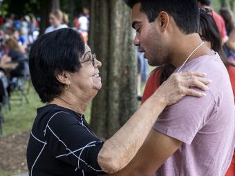 Student and family member hugging at farewell picnic