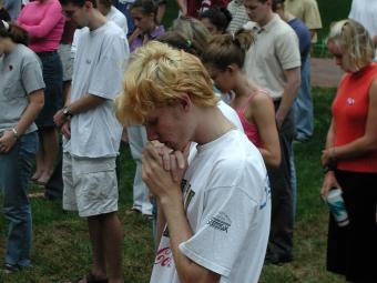 students with heads bowed down in prayer on Chambers lawn