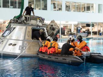 Water Survival Training at NASA where boat floats next to space shuttle capsule