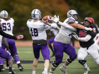 Davidson Football Player Reaches for Ball While Being Tackled, Opposing Player is Throwing Ball