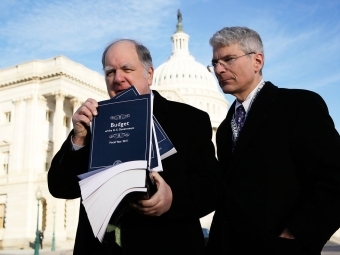 Thomas Kahn and John Spratt outside the White House holding file of papers