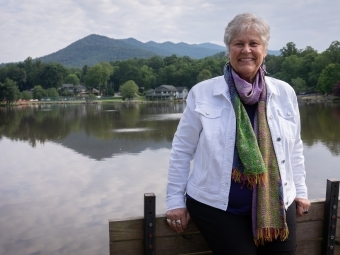 Ruth pittard smiles behind lake and mountains