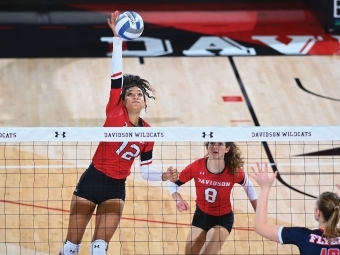 Volleyball Players Hitting Ball Over Net