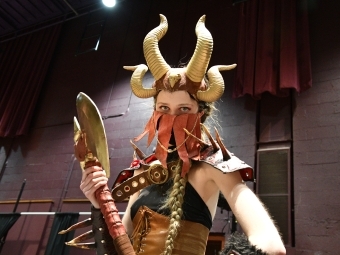 Emma Goldfarb '24 in theatre costume with 4 horns on her head and two-horned sledge-hammer in her hand