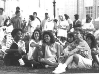 female students sitting outdoors on a campus lawn