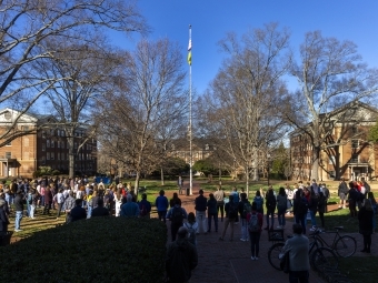 students cast in shade around the Chambers flagpole on a sunny day