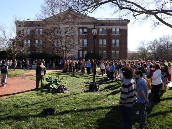gathering of students, faculty and staff around Chambers flagpole for vigil for Ukraine