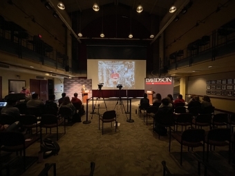 students in the 900 room with Tom Marshburn projected on a screen