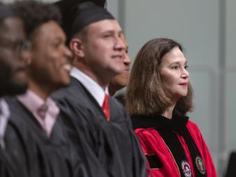 Carol Quillen in a row with other students in cap and gowns at convocation