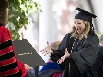 Class of 2020 Commencement excited grad receiving diploma from Carol Quillen