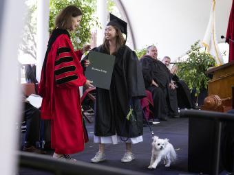 President Carol Quillen hands diploma to student on stage