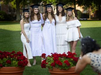 group of graduates with caps on smile for camera 