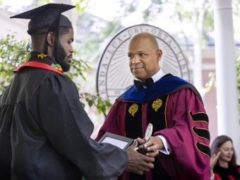 student receiving award from Dean McCrae at Commencement 2022