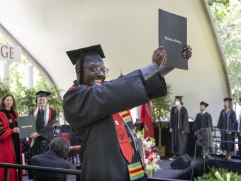 Student holding diploma at Commencement for Class of 2022