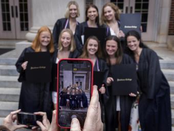 Someone holding phone and taking picture of group of graduates at Class of 2022 Commencement