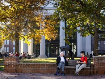 Professor and student talking in front of the library