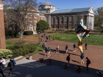 Students walking on campus with Shonibare statue and Chambers building