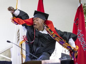Student jumping on stage at Class of 2022 Commencement