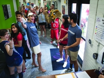 Carol Quillen pointing with crowd of students at event in Lula Bell's 