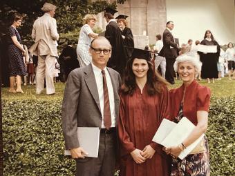 Carol Quillen in cap and gown with family at her commencement ceremony