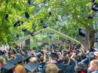 Davidson College Commencement Carol in the background as students throw up their caps