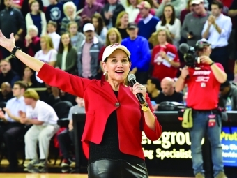 President Carol Quillen holding microphone with audience watching in stands