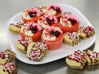 heart-shaped cookies and cupcakes on plate