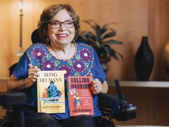 Judy Heumann holding two books