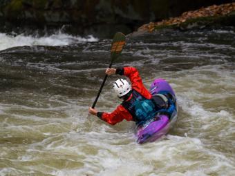 kayaker in rapids at tilt about to go over waterfall