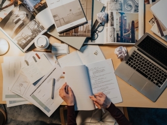 Screenwriter at desk with script and laptop on table