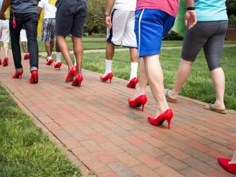 men walking in red high heeled shoes