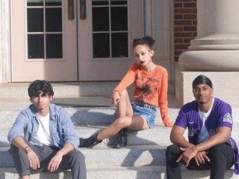 students sitting on stairs looking at camera