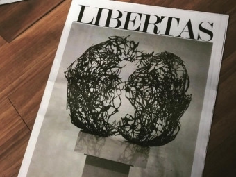 Magazines with art and "LIBERTAS" on cover