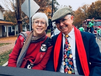 man and woman riding in car with christmas clothes on