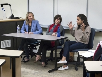 three women speaking at a table