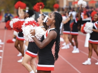 Cheer team performing on the sidelines at a football game