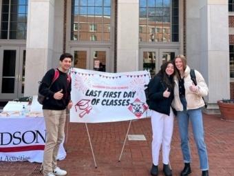 students smiling and standing in front of sign that reads "Last First Day of Classes"