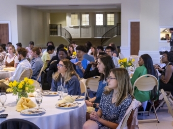 Students sitting at tables in reception space