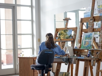 Student painting in art studio