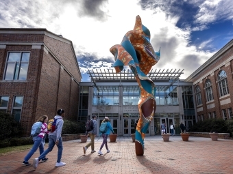 Spring day in front of the Wall Building with Shonibare sculpture and students in the foreground
